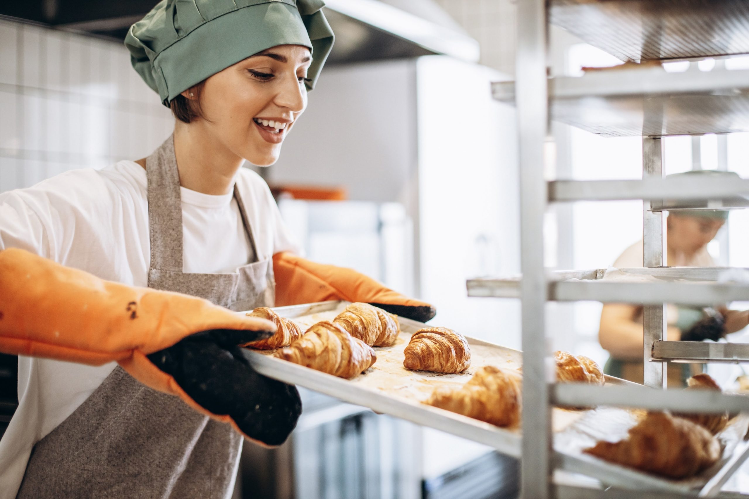 Female,Baker,At,The,Kitchen,Holding,Freshly,Baked,Croiisants